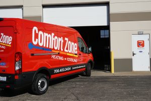Comfort Zone Service truck parked in front of a business's open garage door.