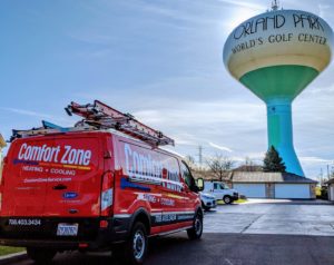 Comfort Zone Service truck parked outside with Orland Park water tower in the background.