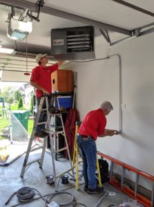 comfort zone service technicians installing garage heater in a garage