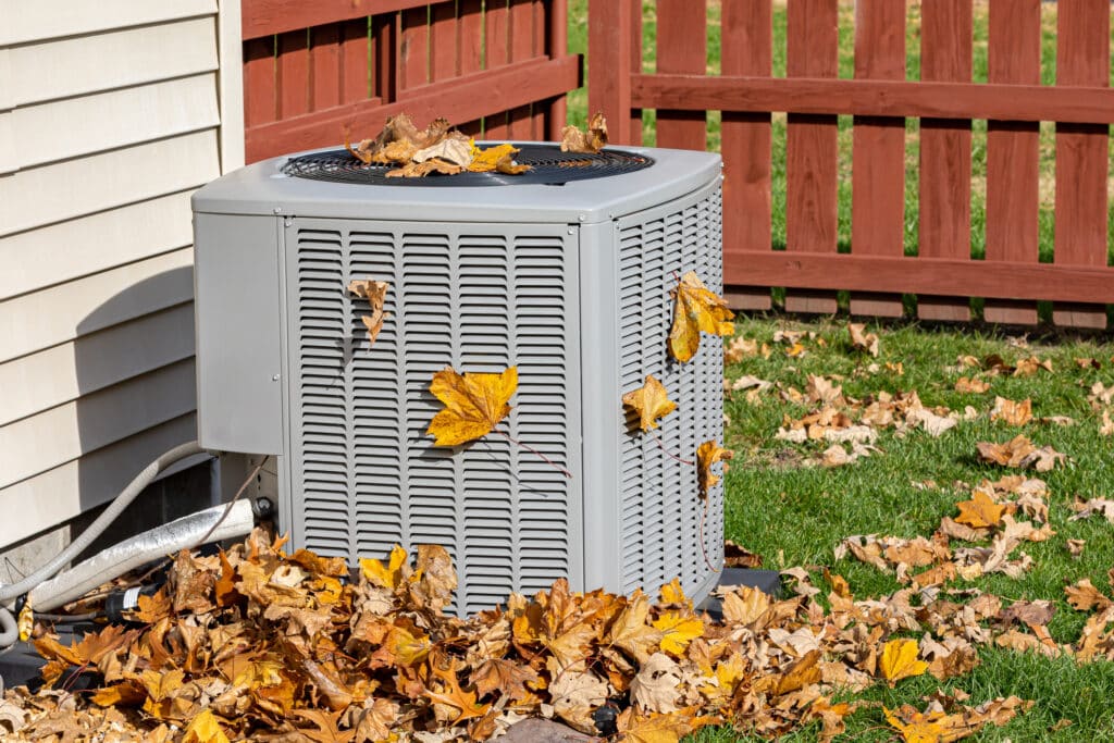 Outdoor HVAC unit full of dry leaves