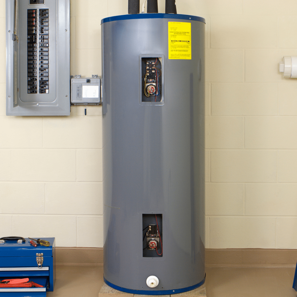 Gray tank water heater next to blue tool box on floor in a basement.