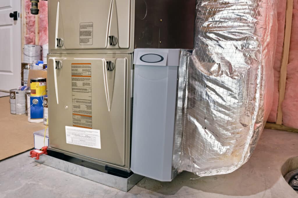A high-efficiency furnace and ductwork in a basement utility room.